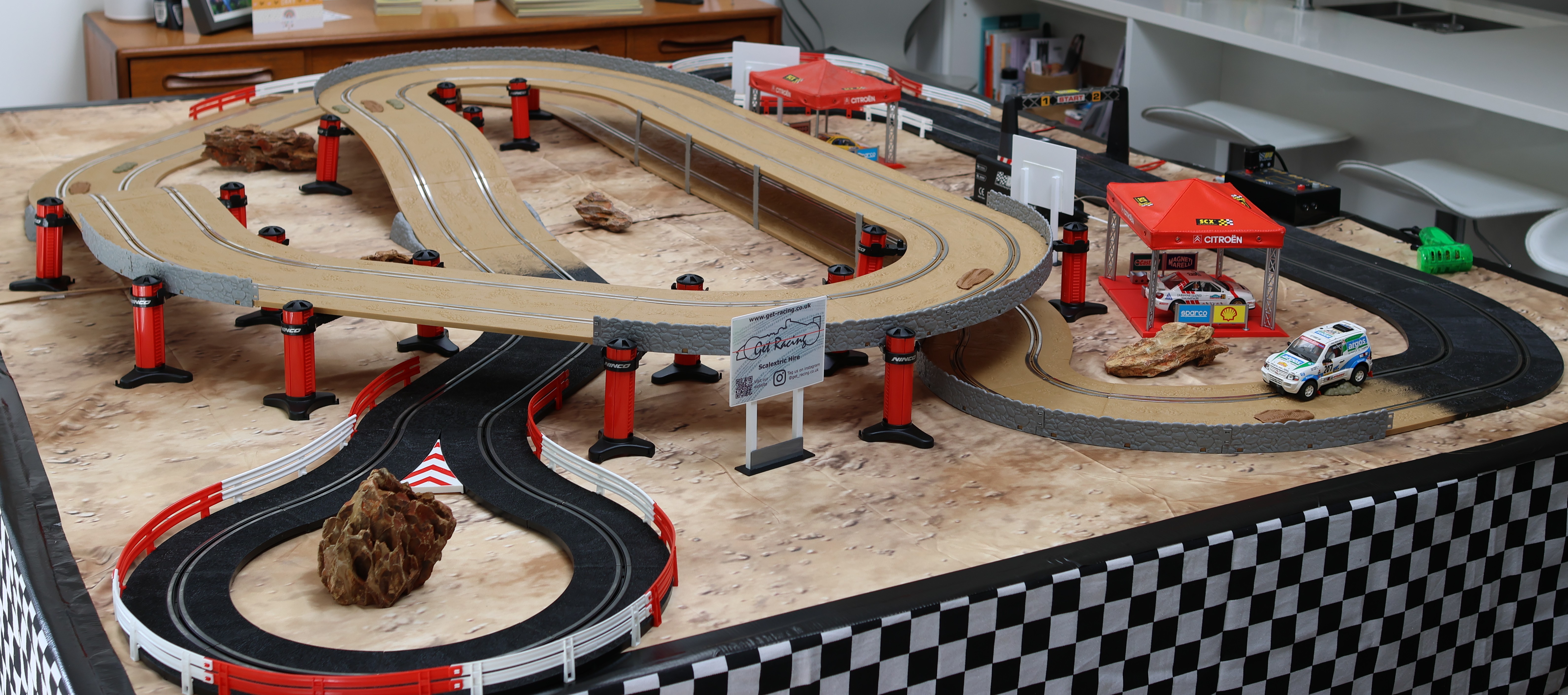 Wide view of the off-road Scalextric track with Get-Racing signage and pit gazebo